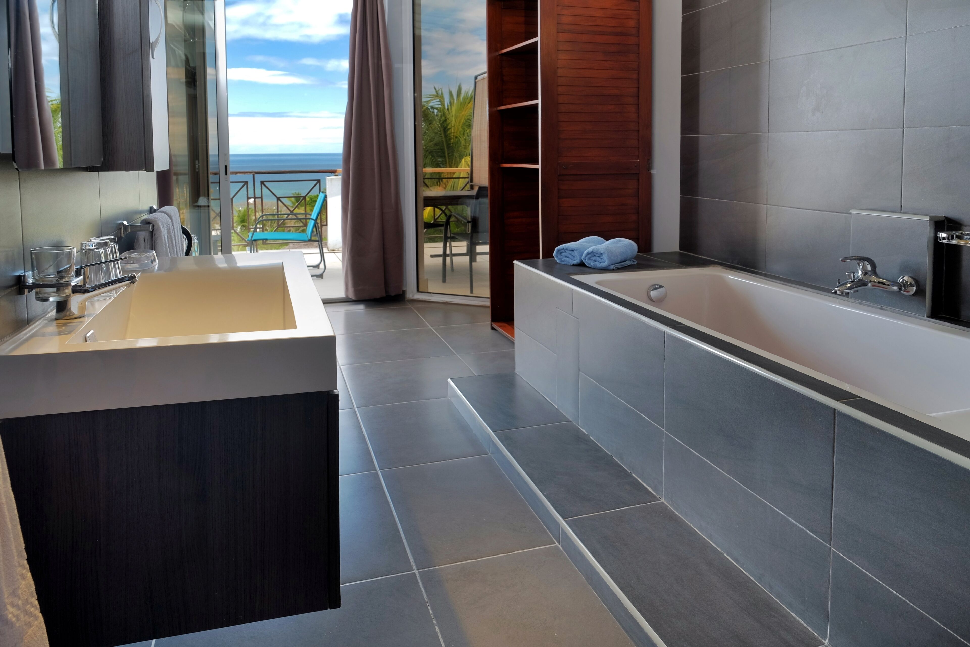 Un baño moderno con una bañera grande, un lavabo y una ducha con mampara de vidrio.