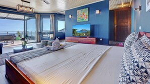 Un dormitorio moderno con una cama grande, un televisor y un balcón con vistas.