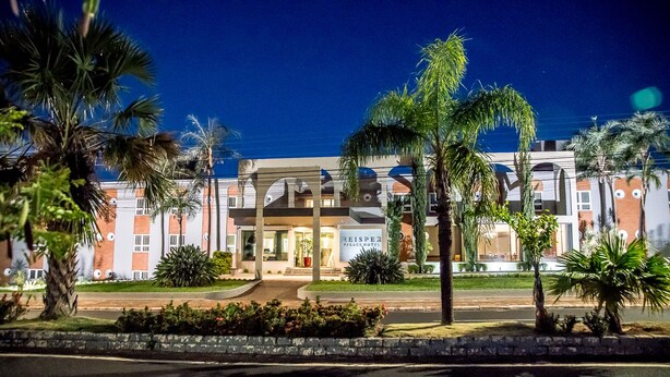 A hotel with a modern facade, a well-maintained garden, and a clear entrance.