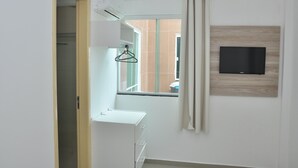 A modern hotel room with a large window, a mounted TV, and a white wardrobe. - Hotel Pousada Salvador (Salvador)