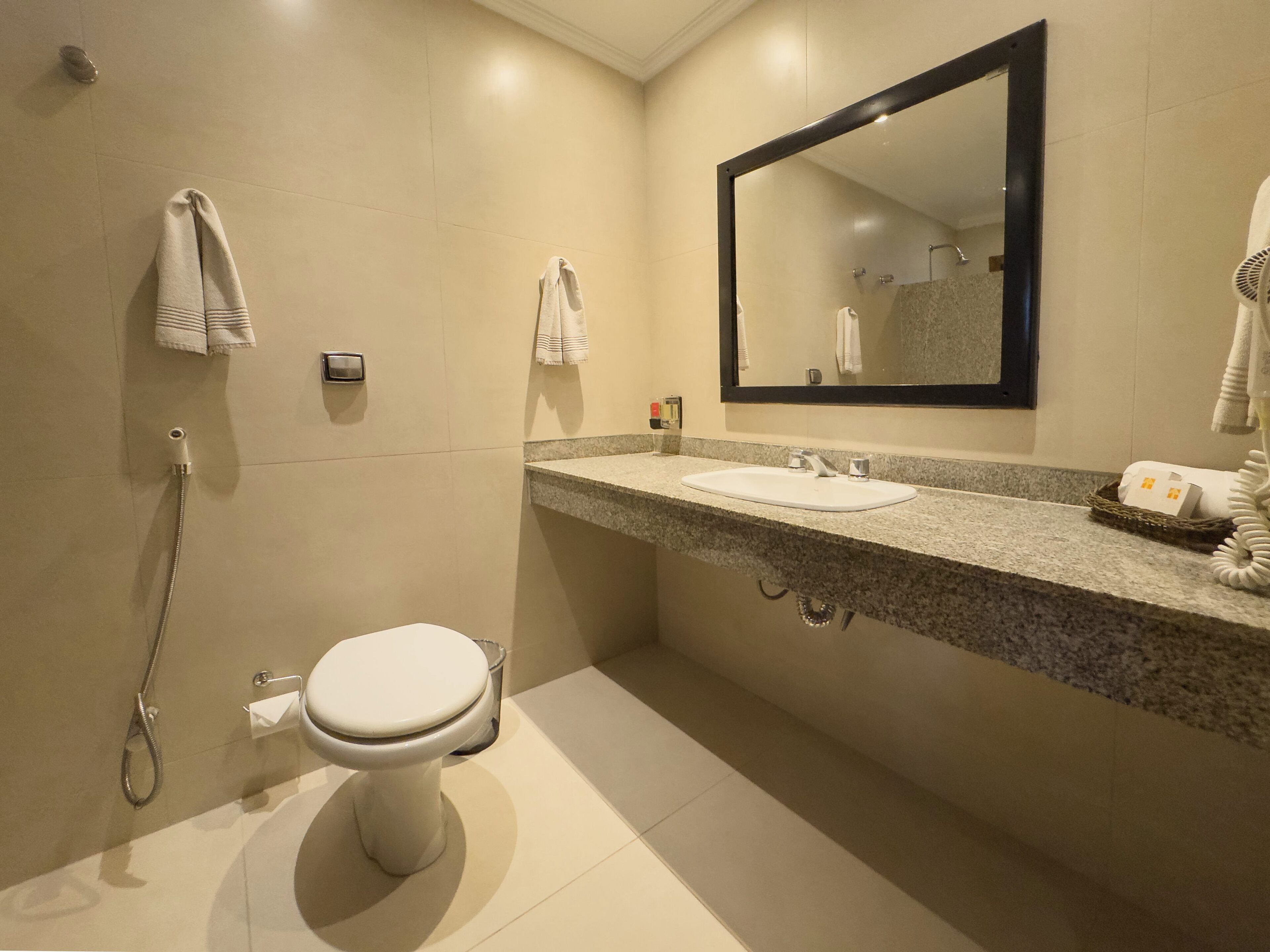 A modern bathroom with a toilet, sink, and shower.