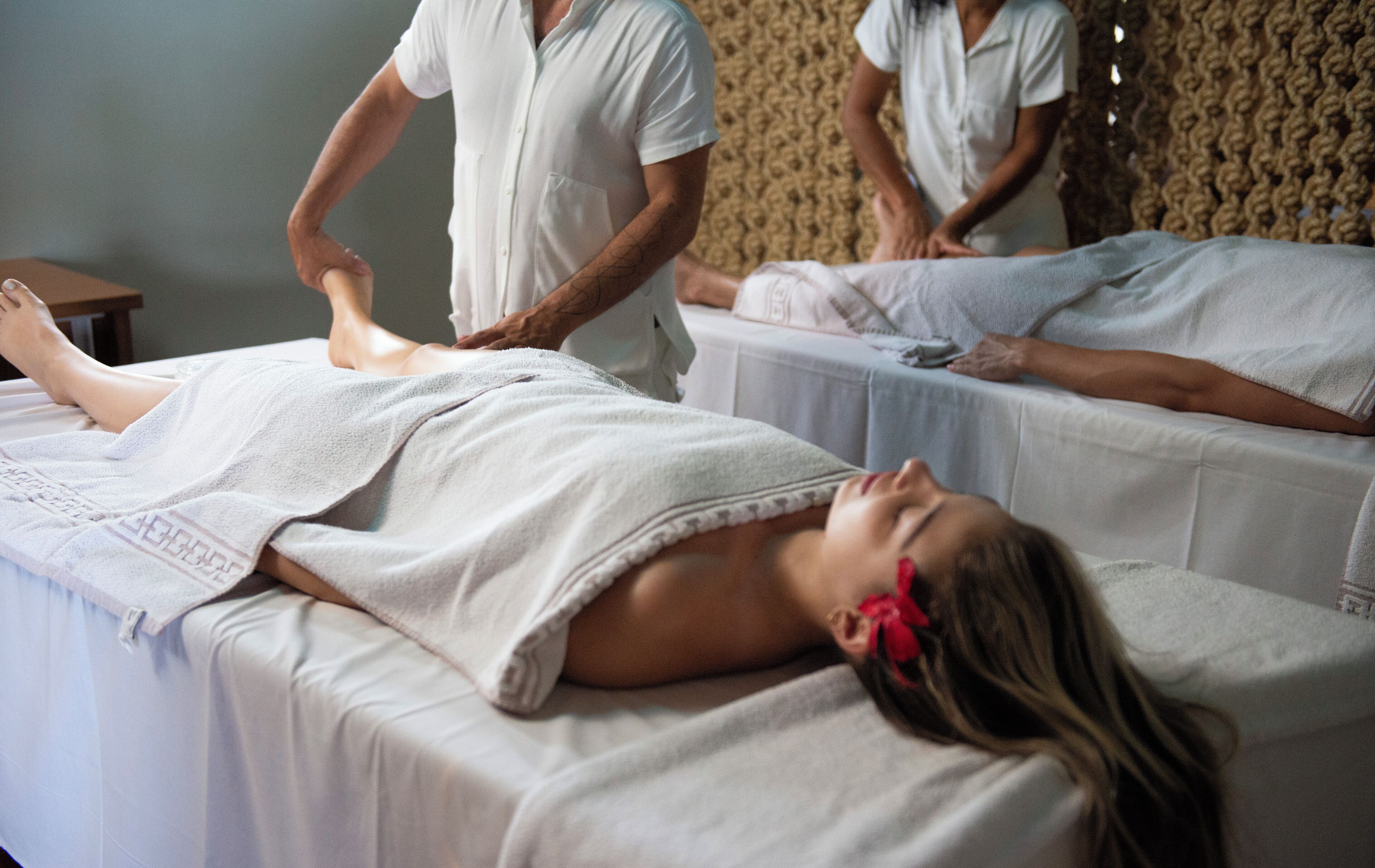 Une salle de massage où deux clients reçoivent des soins.