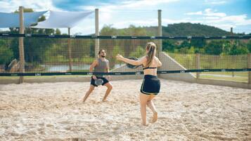 A volleyball game on a sandy court with a net labeled "LIVE!".