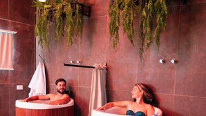 A spa area with two wooden tubs and a wooden bench.