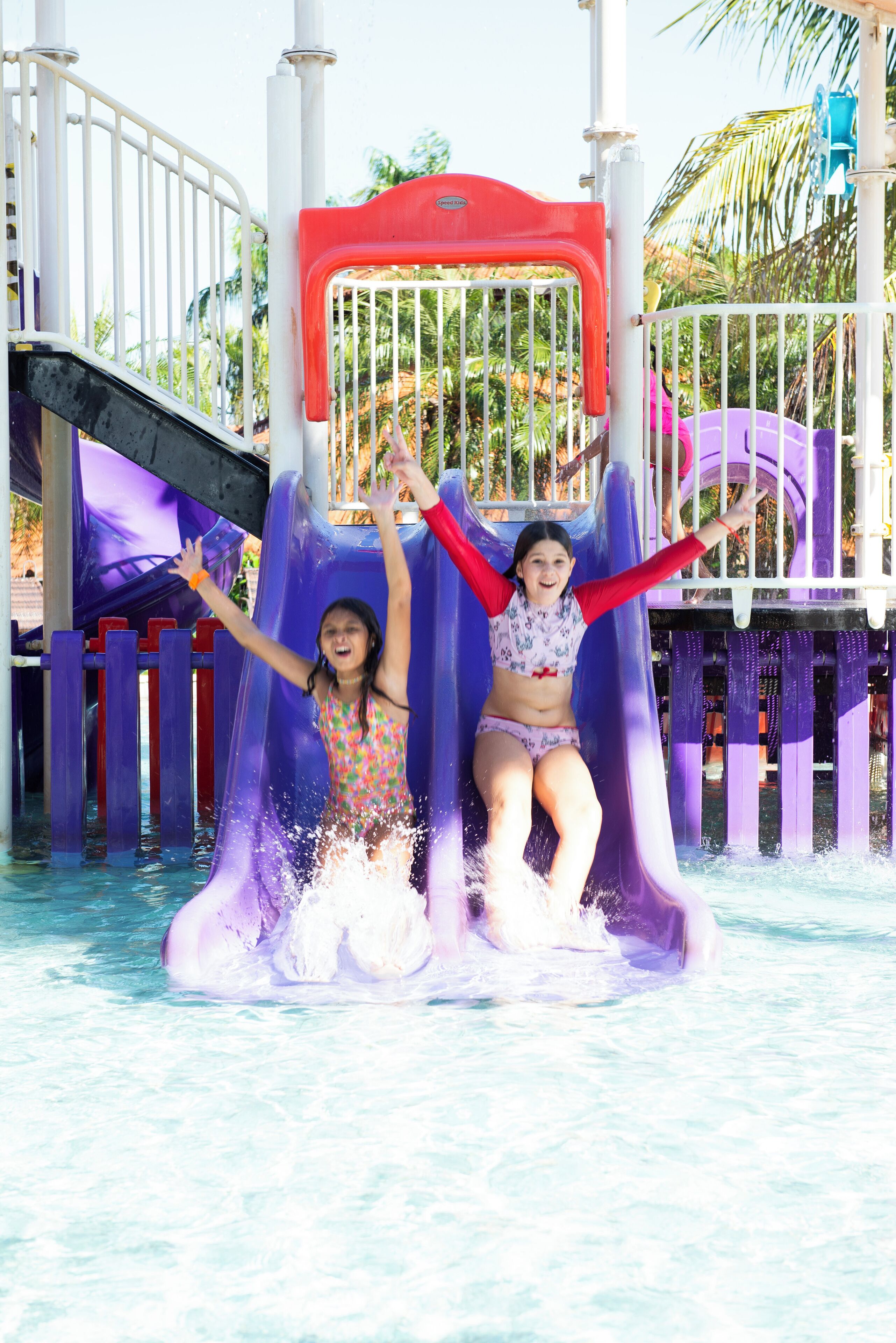 A water park with a purple slide and a red and white structure.
