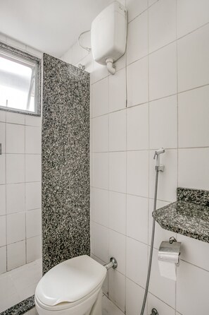 Ein Badezimmer mit Toilette, Dusche und Waschbecken mit Granitablage.