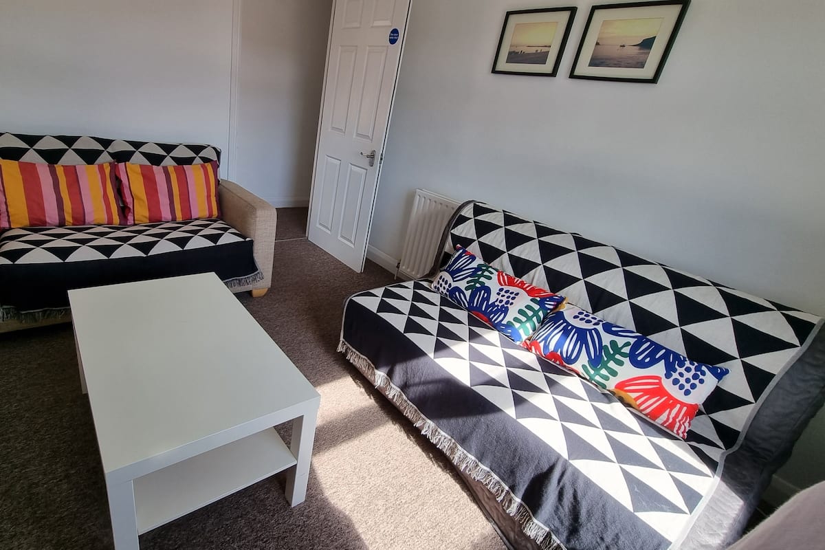 A small, furnished room with a sofa and a white table.