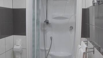 Een moderne badkamer met een douchecabine van glas, een toilet en een wastafel.