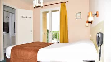 Ein Hotelzimmer mit Bett, Telefon und Blick ins Freie.