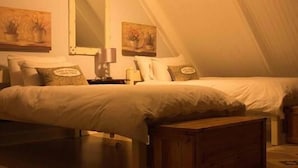 A bedroom with two beds, wooden headboards, and a nightstand with a lamp. - Sweetie Pie Clarens Self Catering Cottages (Clarens)