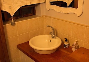 A bathroom with a white sink, wooden countertop, and a mirror above it. - Sweetie Pie Clarens Self Catering Cottages (Clarens)