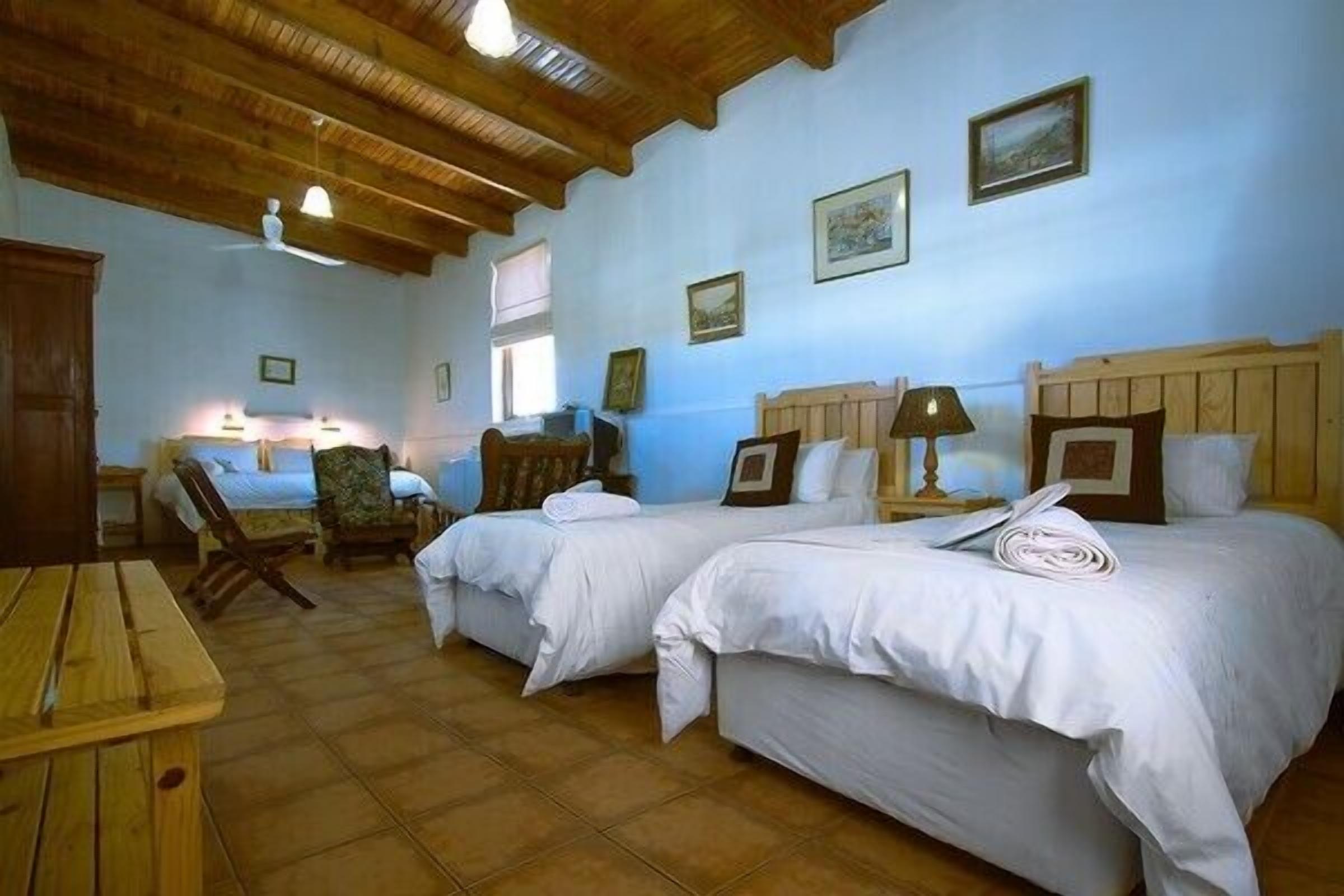 A room with two beds, wooden furniture, and a tiled floor.