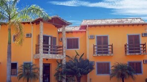 A two-story building with balconies, a central entrance, and a palm tree in the foreground. - Pousada Conchas de Paraty (Paraty)