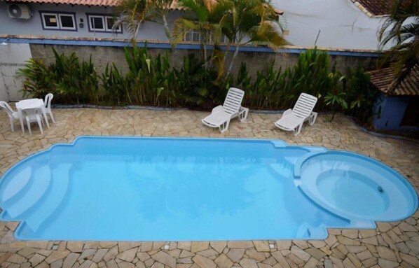 Una piscina al aire libre, tumbonas