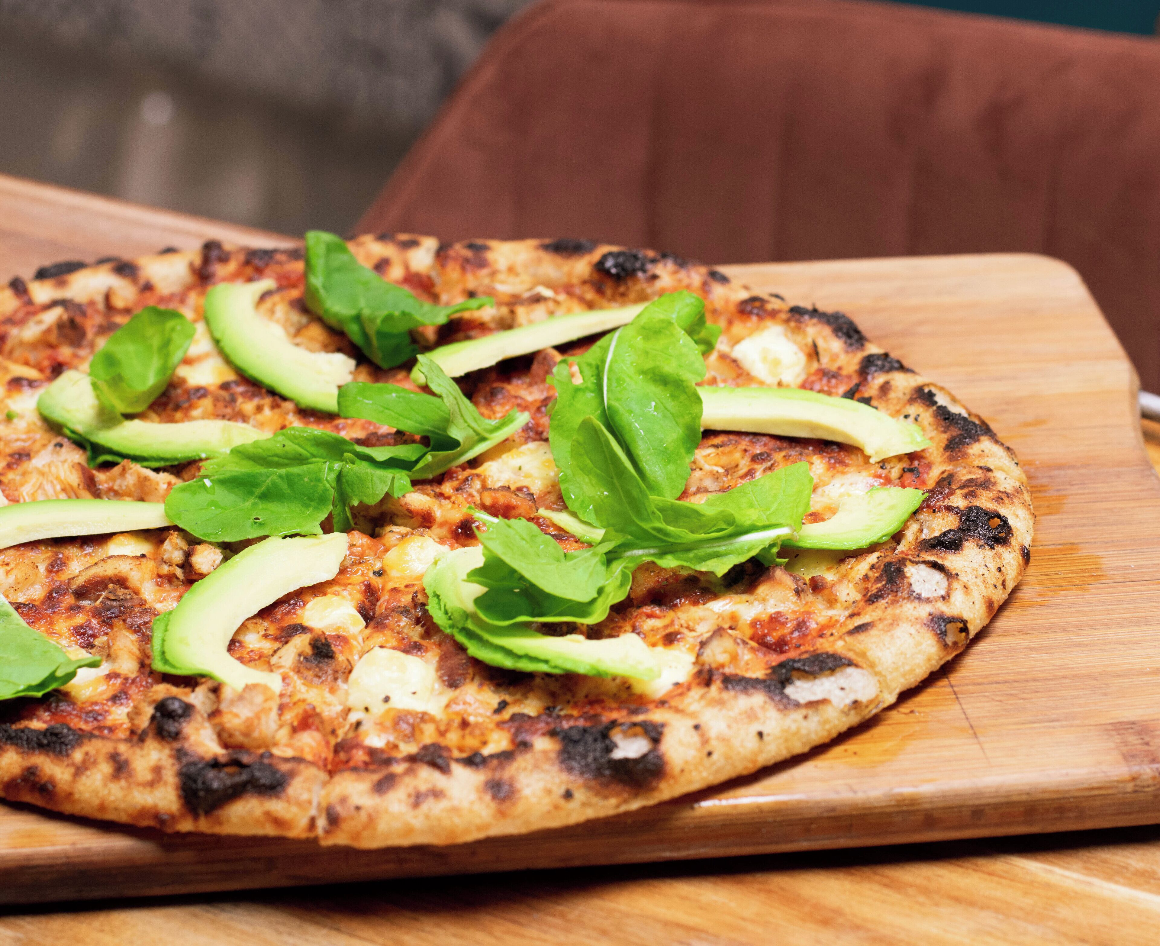 Uma pizza em uma tábua de madeira.
