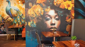 A restaurant interior with a mural of peacocks and flowers, wooden tables, and chairs. - Silver Forest Boutique Hotel, Spa, Restaurant & Bar (Cape Town)