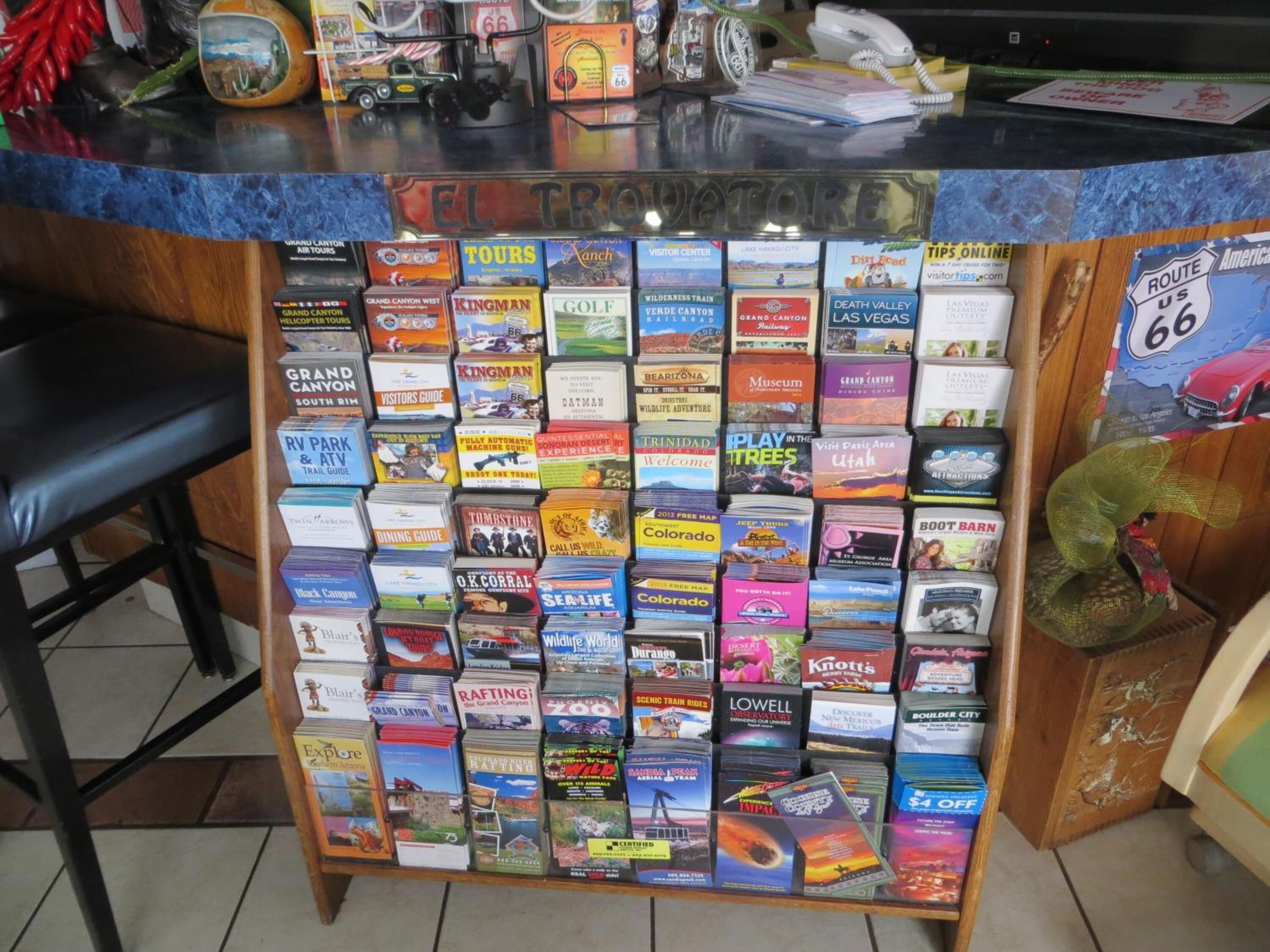 A travel information desk with a variety of guidebooks and maps for different destinations.
