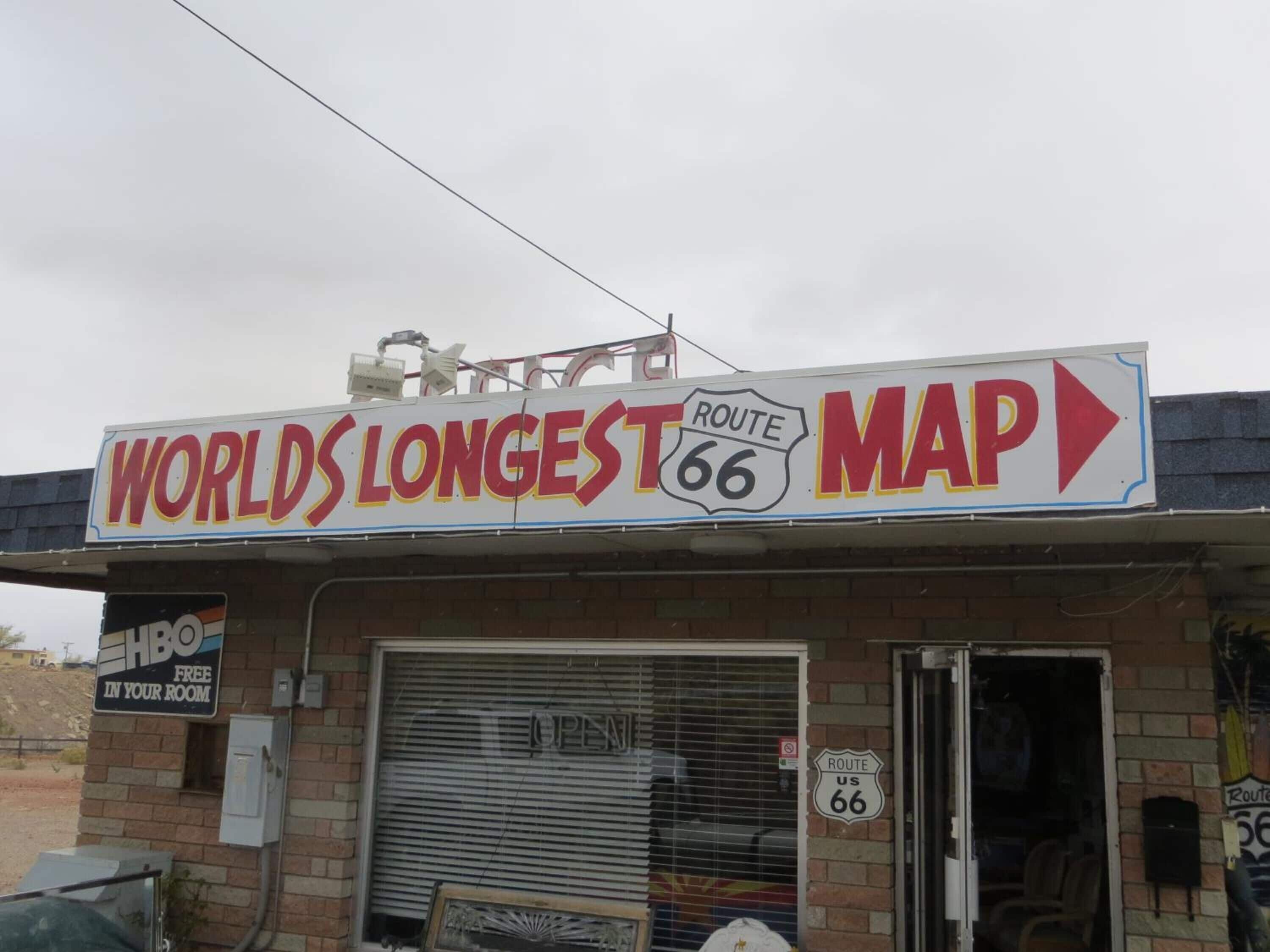 A storefront with a sign for 'World's Longest Map' and Route 66.