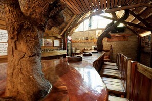 A rustic bar area with wooden benches and a polished bar counter.
