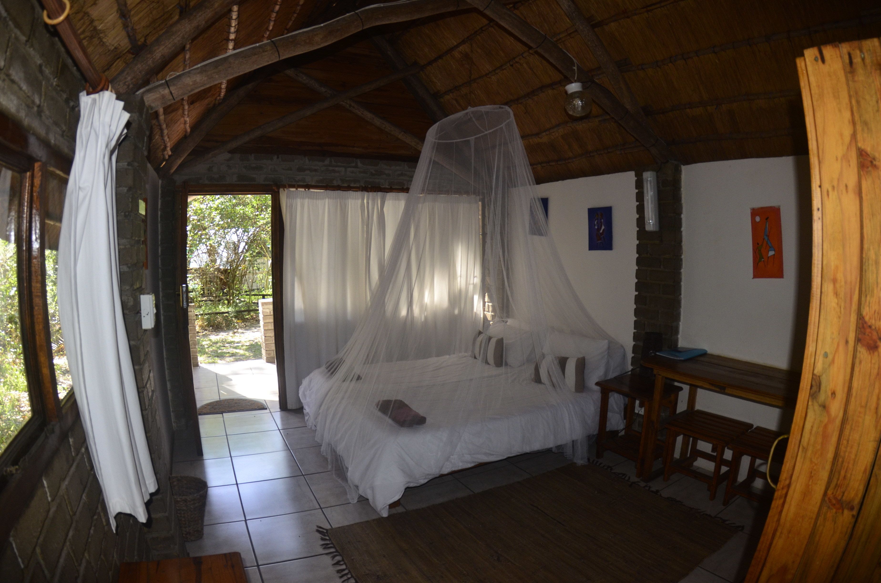 A room with a bed, a wooden bench, and a table.