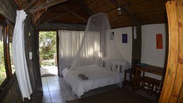 A room with a bed, a wooden bench, and a table.