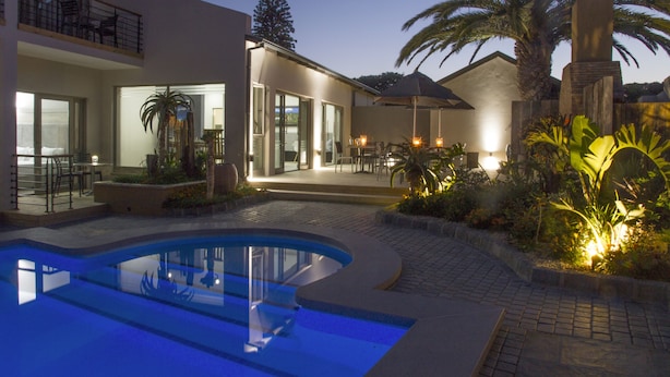 A modern house with a swimming pool, outdoor seating, and a well-lit patio area. - Ocean Bay Guest House (Gqeberha (Port Elizabeth))