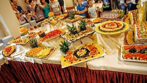 A buffet table with various food items and a crowd of people around it. - Jole (Cesenatico)