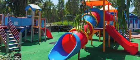A playground with multiple slides and climbing structures.