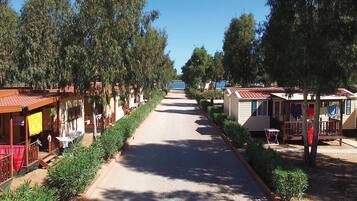 Una hilera de casas móviles con un sendero pavimentado entre ellas, rodeadas de árboles.