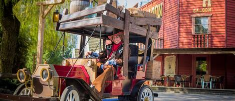 Ein historischer Feuerwehrwagen, gesteuert von einer Person mit Cowboyhut.
