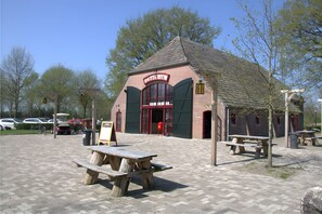 A building with a "Check-in" sign, picnic tables, and a brick exterior.