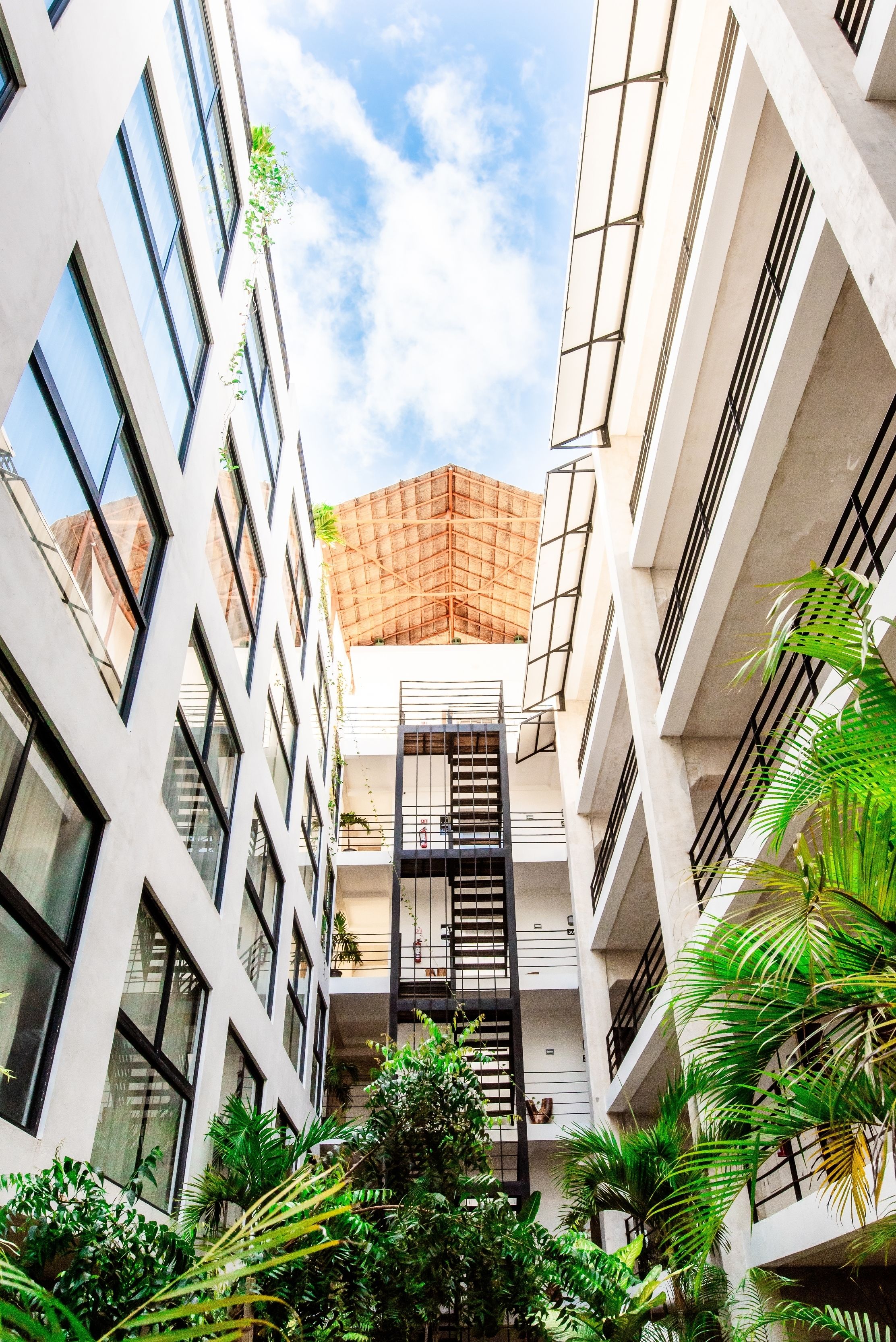 A multi-story building with a central atrium, large windows, and a staircase leading to the upper floors.