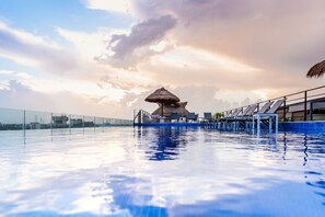 Una piscina al aire libre, sillones reclinables de piscina