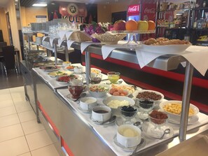 A buffet setup with various food items and beverages. - Hotel Arena (Minsk)