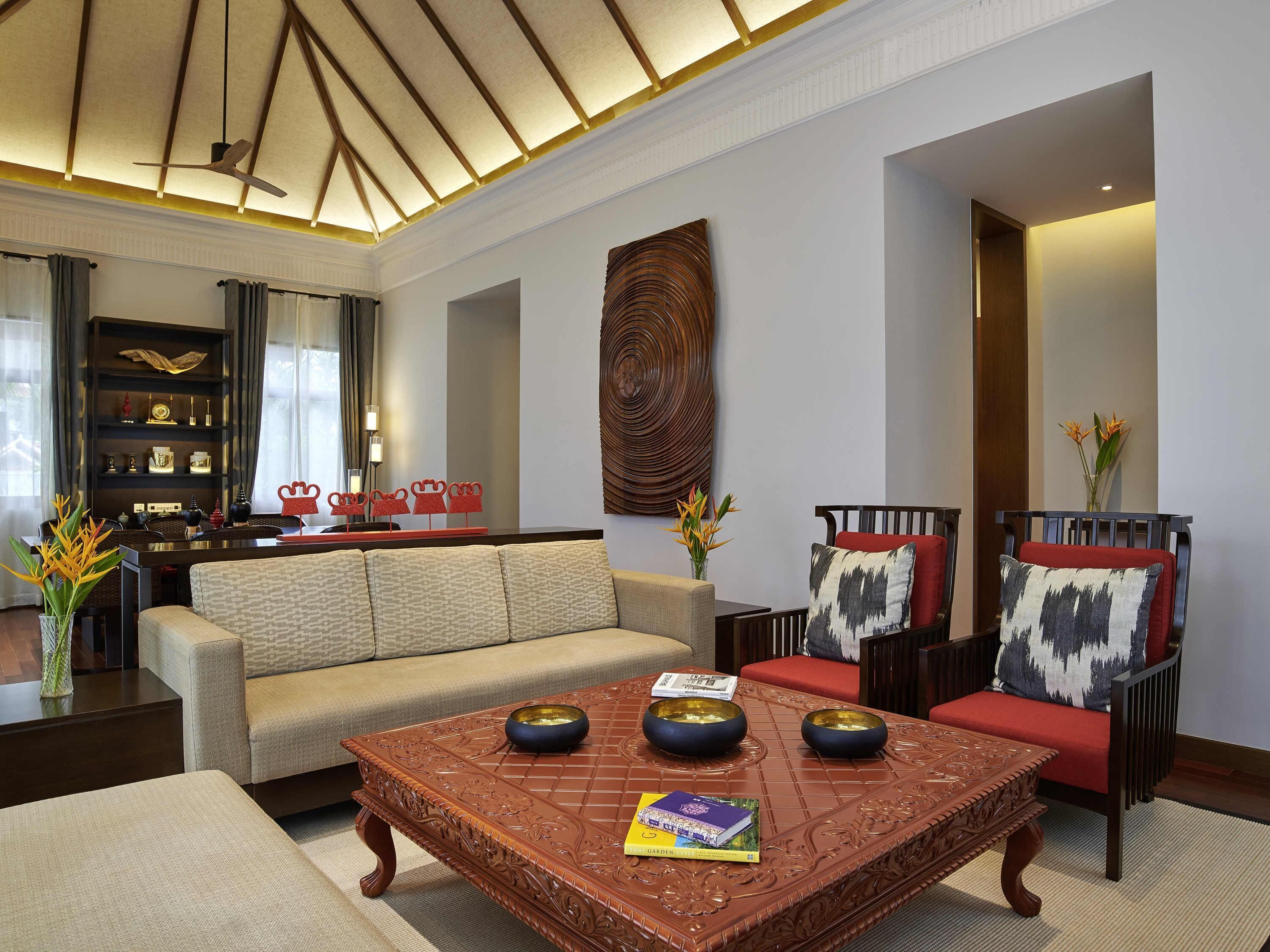 Una sala de estar moderna con un sofá, sillones, una mesa de centro y una estantería.
