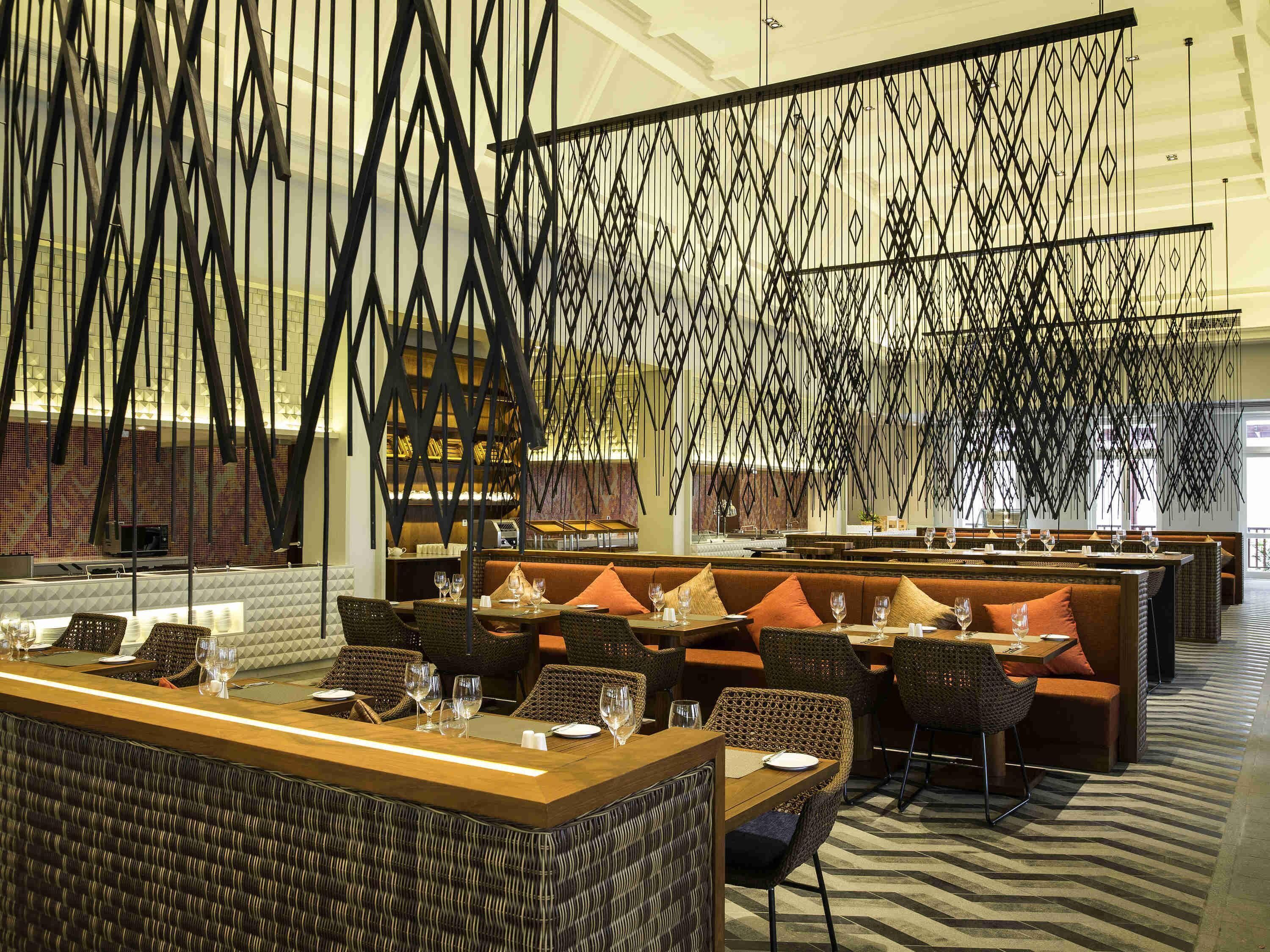 En restaurant med højt til loftet, moderne indretning og et mønstret gulv.