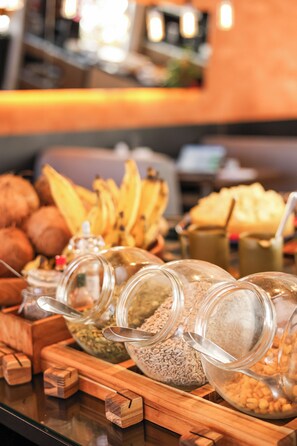 Diversos alimentos expuestos en recipientes de vidrio sobre una tabla de madera.