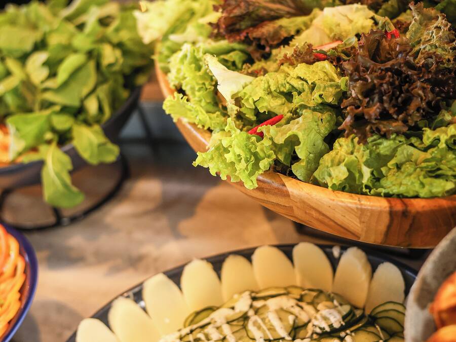 A buffet with various salads and a cucumber dish.