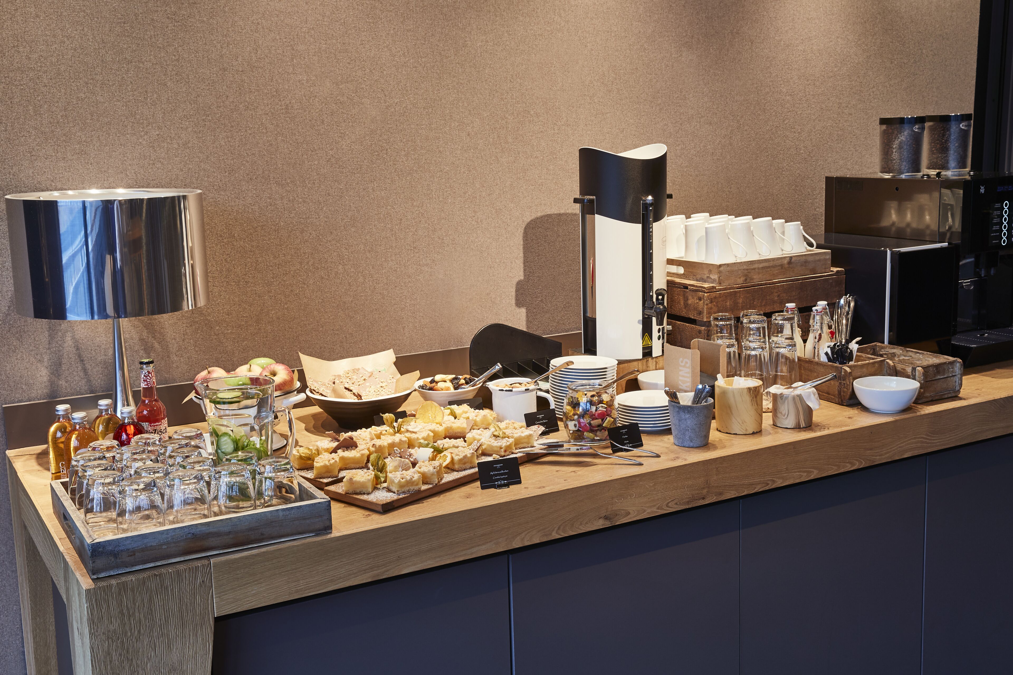 A buffet setup with various food items, a coffee machine, and a coffee urn.