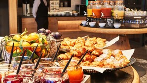 A breakfast buffet with fruits, pastries, and beverages. - Steigenberger Hotel München (Munich)