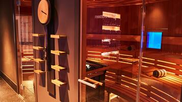 Ein Saunaraum mit Holzbänken und einer sichtbaren Sauna-Wanne.