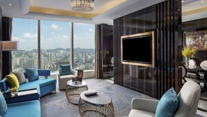 Un salon moderne avec vue sur la ville, un grand téléviseur à écran plat et un mobilier élégant.