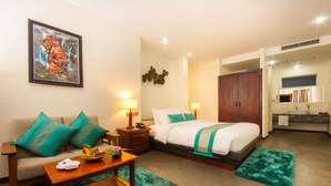 A hotel room with a bed, a sofa, a small table, and a painting on the wall. - The Privilege Boutique (Siem Reap)