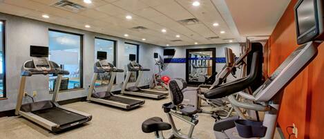A gym with treadmills, elliptical machines, and a stationary bike.