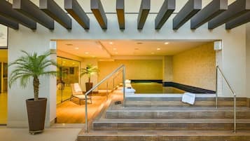 Step into a welcoming space with a reception area, seating area, and pool in the background.