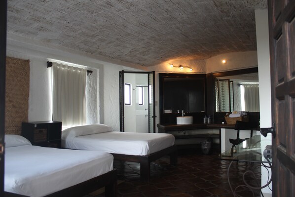 A room with two beds, a bathroom with a sink and mirror, and a tiled floor. - Hotel Casa Blanca San Miguel (San Miguel de Allende)