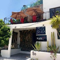 Un hotel llamado 'Hotel Casa Blanca' con asientos exteriores y una cafetería.