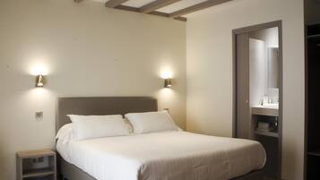 Una camera da letto con un letto, lampade da comodino, un comodino e un armadio.