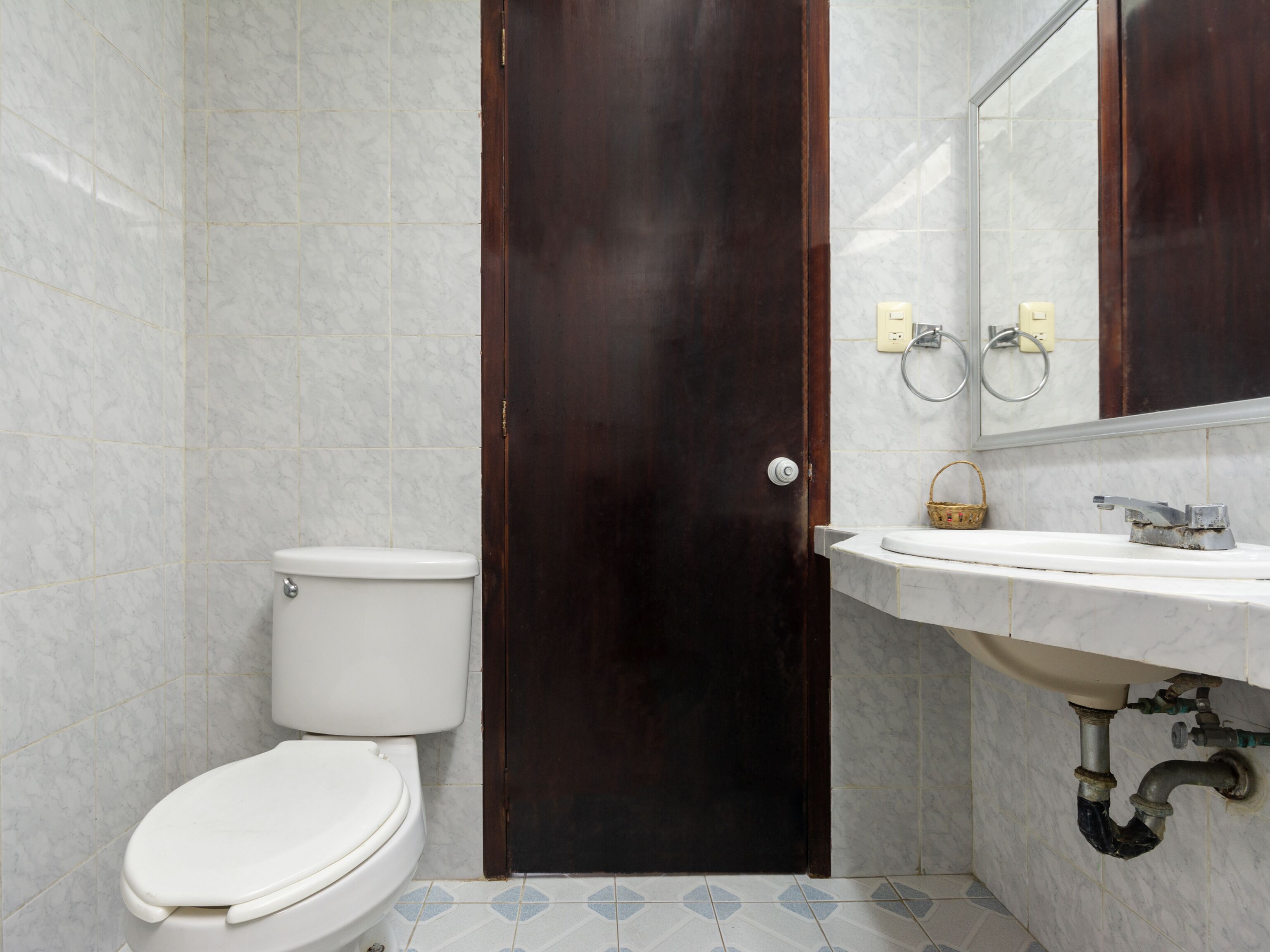 Une salle de bain avec des toilettes, un lavabo et un miroir.