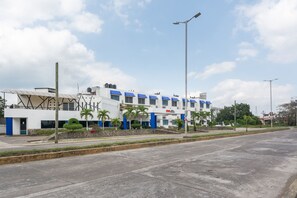 A modern building with a white facade and blue accents, featuring a flat roof and multiple windows. - OYO Hotel Casa Blanca (Martínez de la Torre)